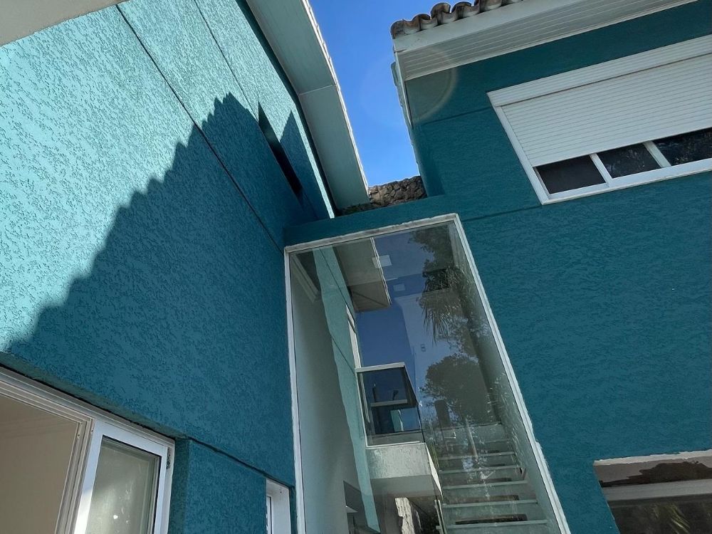 Fachada de casa com textura azul aplicada, vista de baixo contra o céu